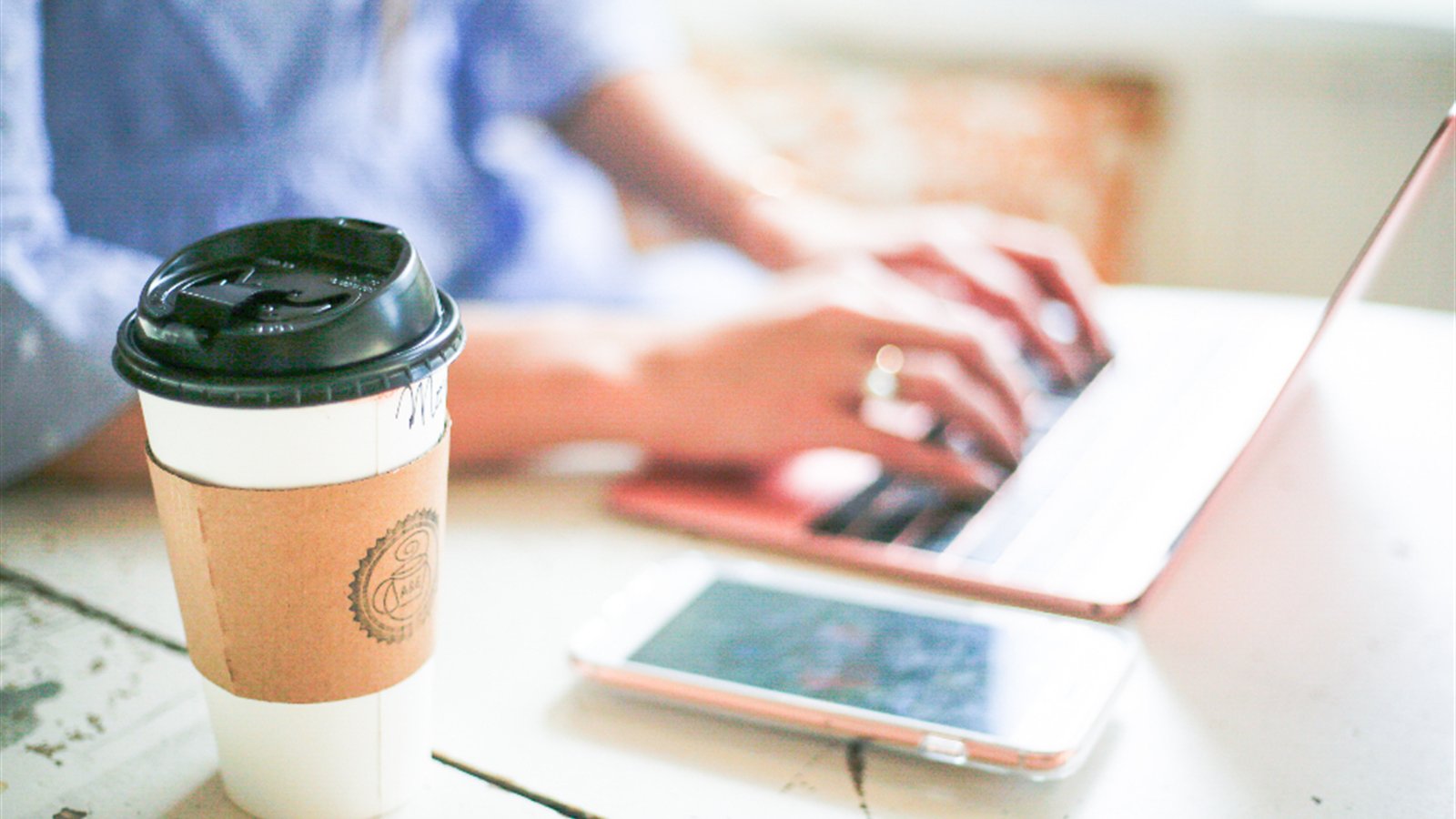 カフェのテーブルに置かれたコーヒーとスマートフォン